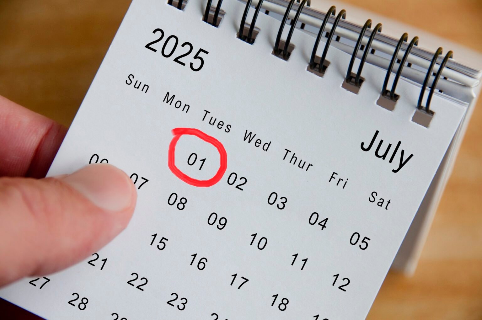 Close up view of July 2025 Calendar on wooden desk background. Calendar concept.