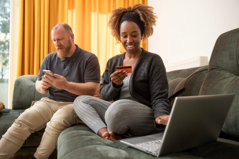 Mixed race couple working on personal finance on the sofa at home
